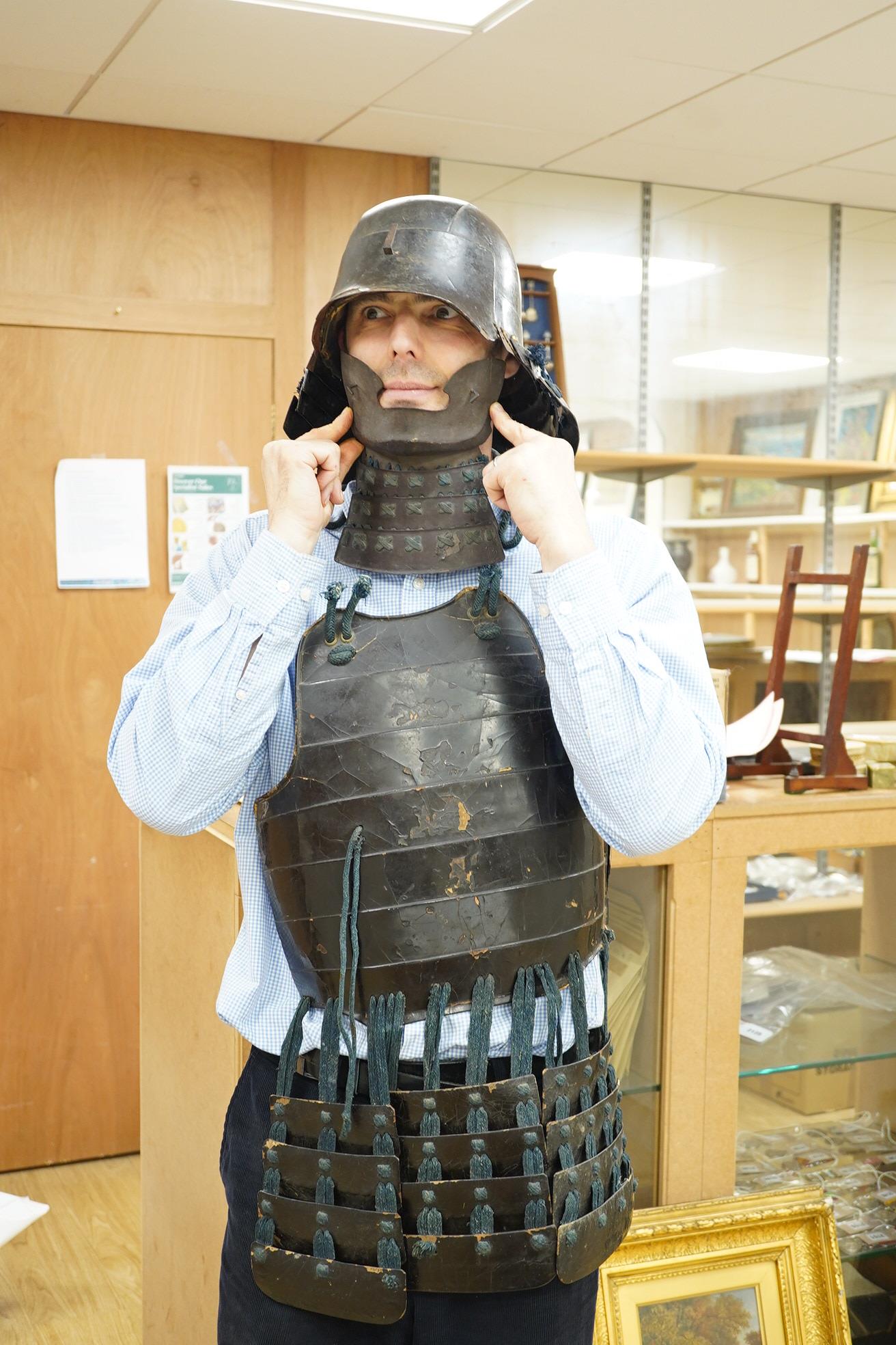 A Japanese armour, 19th century or earlier comprising; helmet Kabuto of five plates covered in black lacquer with 4-plate shikoro, also an iron lacquered mempo with three lames to throat and a do opening at side, embosse